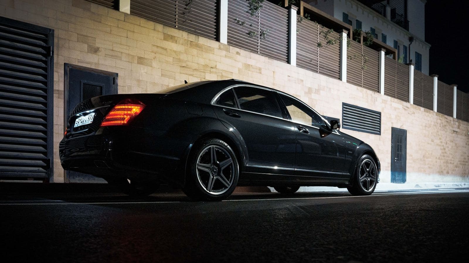 A black sedan waiting at the curb at night